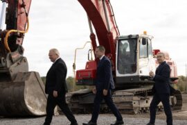 Ontario Premier Doug Ford, Umicore CEO Mathias Miedreich and Innovation and Science and Industry Minister Francois-Philippe Champagne make their way past heavy equipment to a ceremonial ground breaking ceremony, in Millhaven, Ont., Monday, Oct. 16, 2023.